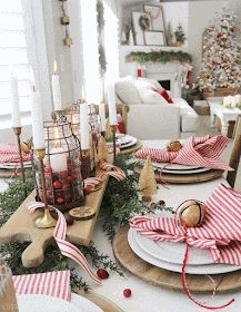 a christmas table setting with red and white striped napkins