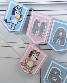 the letters and numbers are decorated with cartoon characters on them, hanging from clothes pins