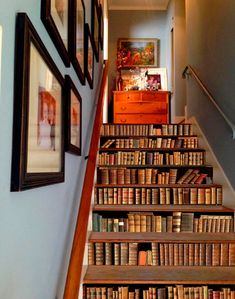 the stairs are lined with books and framed pictures