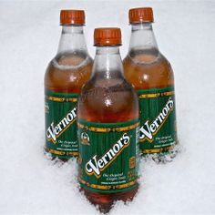 three bottles of vermouth are sitting in the snow on top of each other