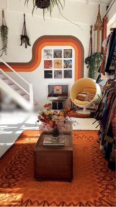 a living room filled with furniture and lots of hanging plants on the wall next to a stair case