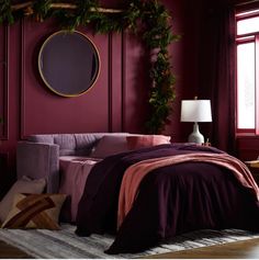 a bedroom with red walls and purple bedding