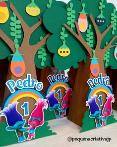 some paper trees with numbers on them and decorations in the shape of animals, plants and birds