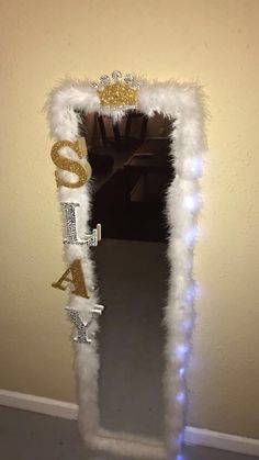 a mirror decorated with white fur and gold letters