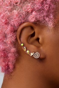 a woman with pink hair wearing ear piercings