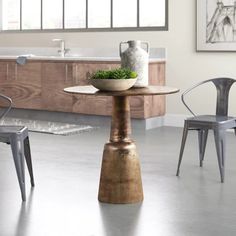 a table with two chairs and a bowl of vegetables on it in a kitchen area