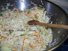 shredded carrots and cabbage in a pan with a wooden spoon