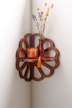 a wooden shelf with vases and candles on it in a corner next to a wall