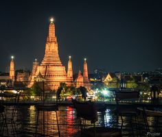 an image of a city at night with the lights on and buildings reflected in the water