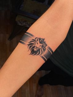 a man's arm with a lion tattoo on the left side of his arm