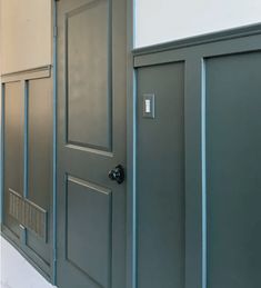 an empty room with two gray doors and white walls