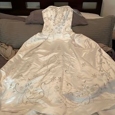 a wedding dress is laying on the bed