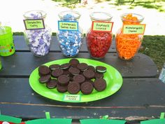 a table topped with lots of cookies and candies on top of a green plate