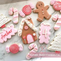 some decorated cookies are sitting on a counter top with pink and white frosted icing