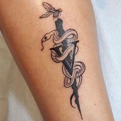 a tattoo on the leg of a person with a snake and dagger in its hand