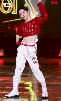 a man in red shirt and white pants on stage