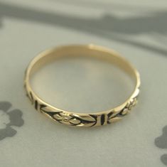 "Gold Antiqued Ring~Gold Wedding Band~Orange Blossom Ring~Romance Band~Antiqued Gold Band~Black Gold Ring~Women Gold Ring~Vintage Style Ring Introducing our new ANTIQUED Gold Bands! This solid 14K gold ring is hand crafted from preformed pattern wire. It features a lovely floral design and can be custom made in any ring size. The detail is so exquisite it looks as if it was hand engraved! Measuring 2.8mm (just under 1/8\") wide and a slim .75mm thick, it is perfect as a petite wedding ring or st Gold Rings With Antique Finish For Wedding, Gold Wedding Ring With Antique Finish, Vintage Wedding Toe Ring With Flower Design, Vintage Wedding Flower Toe Ring, Vintage Yellow Gold Stackable Wedding Rings, Vintage Yellow Gold Band Ring, Elegant Antique Finish Wedding Rings, Vintage Flower Ring With Intricate Design For Wedding, Ornate Ceremonial Rings With Decorative Band