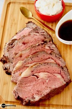 the meat is sliced up and ready to be served on the cutting board with sauce