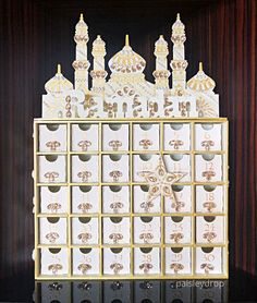 a gold and white clock sitting on top of a wooden shelf next to a wall