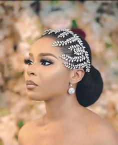 a woman with an elaborate head piece in her hair and makeup looks off to the side