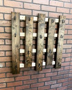 a brick wall with three wooden boards mounted to it's sides and two hooks on each side