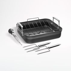 an assortment of cooking utensils including a roasting pan and tongs