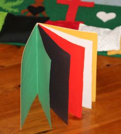 an open book sitting on top of a wooden table next to other folded paper items