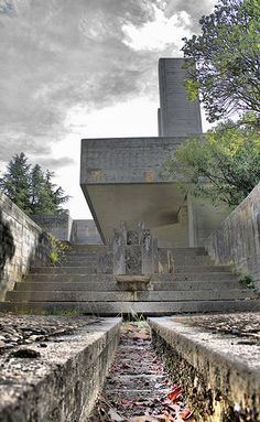 an abandoned building with steps leading up to it and a fountain in the foreground