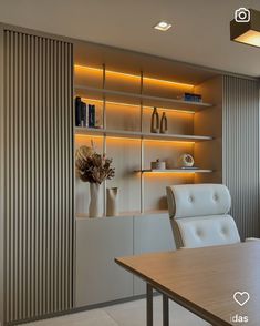 a room with a table, chairs and bookshelves on the wall in front of it