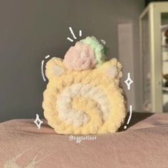 a crocheted stuffed animal is sitting on a bed