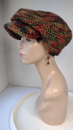 a white mannequin head wearing a multicolored knitted clochet hat