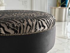 a zebra print ottoman sitting on top of a marble floor