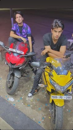 two men are sitting on motorcycles in the street