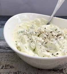 a white bowl filled with mashed potatoes on top of a wooden table