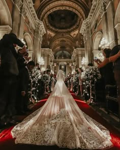 the bride is walking down the aisle in her wedding dress