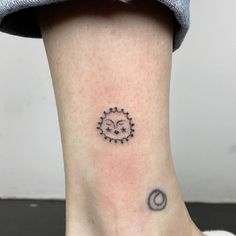 a small sun and moon tattoo on the ankle