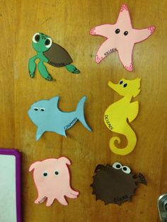 several different colored sea animals on a wooden surface