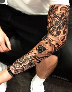 a man sitting down with a tattoo on his arm