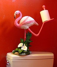 a pink flamingo standing on top of a toilet