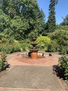 a brick fountain surrounded by trees and bushes