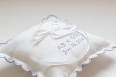 a white handkerchief with a blue trim around the edge and an embroidered name on it