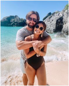 a man and woman hugging on the beach