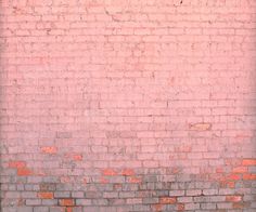 a red fire hydrant sitting in front of a brick wall