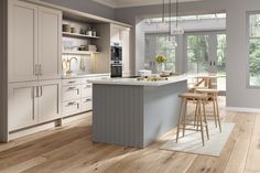 a large kitchen with white cabinets and wooden floors