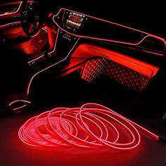 the interior of a car with red neon lights and wires on the floor next to it