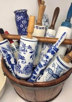 a wooden basket filled with blue and white vases