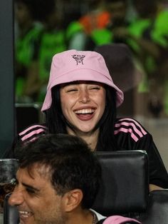 a woman wearing a pink hat sitting next to a man