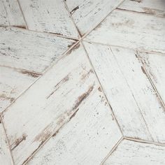 an old white wood floor textured with peeling paint and chipped off in the middle