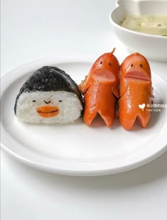 a plate topped with sushi and two penguins