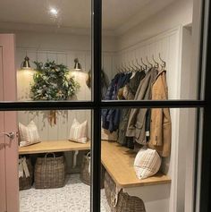 there is a closet with clothes on the shelves and other items in baskets next to it